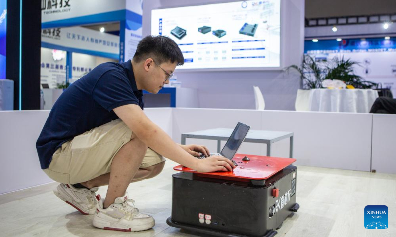 An exhibitor debugs an autonomous mobile robot at the venue for 2023 Smart China Expo in southwest China's Chongqing, Sept. 3, 2023. The 2023 Smart China Expo will be held at Chongqing International Expo Center from Sept. 4 to 6. (Xinhua/Chu Jiayin)