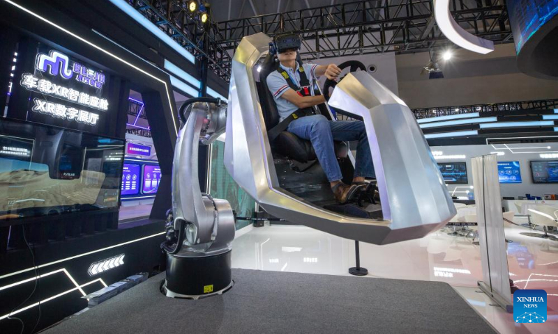 A journalist experiences an in-vehicle XR intelligent cabin at the venue for 2023 Smart China Expo in southwest China's Chongqing, Sept. 3, 2023. The 2023 Smart China Expo will be held at Chongqing International Expo Center from Sept. 4 to 6. (Xinhua/Chu Jiayin)