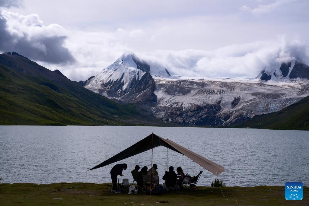 Tourists enjoy the lake scenery at the foot of the Sapukonglagabo Mountain in Biru County of Nagqu, southwest China's Tibet Autonomous Region, Aug. 16, 2023.(Photo: Xinhua)