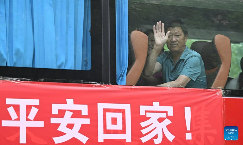 Villagers wave in a bus as they are going back home from a relocation site in Xiqing District, north China's Tianjin Municipality, Aug. 20, 2023. All of over 37,000 relocated villagers from the Dongdian flood storage and retention area in Jinghai District of north China's Tianjin have returned to their homes as floodwater receded. Photo: Xinhua