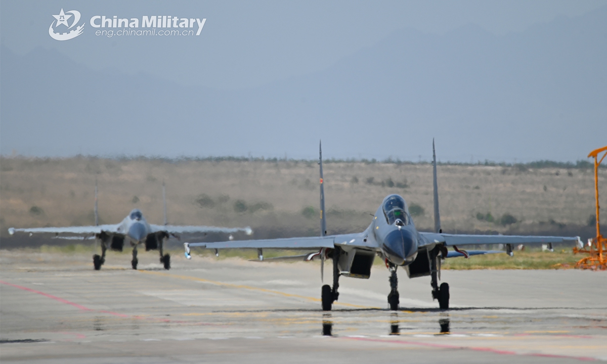 Two J-11 fighter jets attached to an air station of the air force under the PLA Western Theater Command taxi on the runway before taking off during a force-on-force red-blue exercise held in recent days. (eng.chinamil.com.cn/Photo by Yu zeqi)