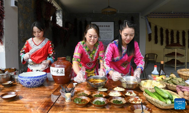 Staff members prepare food at a snack shop in Dingshi Township, Youyang Tujia and Miao Autonomous County, southwest China's Chongqing Municipality, on Aug. 20, 2023. Youyang, one of the key beneficiary counties of state assistance for rural revitalization, has been fully availing of its unique advantages in ecological environment and indigenous tradition to promote converged development of agriculture, culture, and tourism.(Photo: Xinhua)