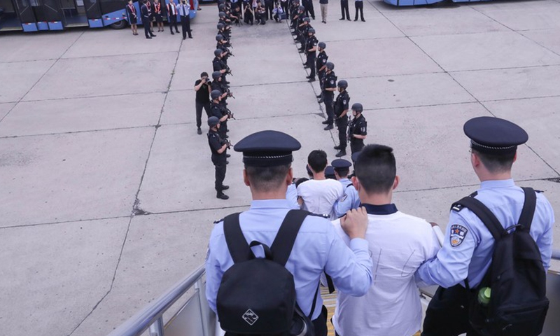 File photo shows the police escort a telecom fraud suspect to the Capital International Airport in Beijing, capital of China, June 7, 2019. (Xinhua/Yin Gang)