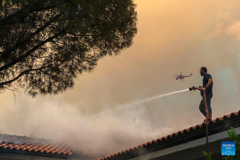 A volunteer works to control a wildfire near Athens, Greece, on Aug. 23, 2023. Wildfires raging around Greece's capital spread to the Mount Parnitha National Park, northwest of Athens, on Wednesday, the Fire Brigade said. The blaze that broke out on Tuesday at the mountain's foot has already damaged homes and scorched forested land. Nearby settlements and a migrant camp were evacuated as a precautionary measure.(Photo: Xinhua)