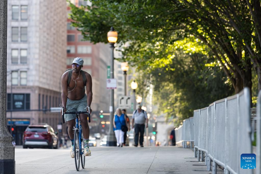 A biker goes through downtown Chicago with shirts off, the United States, on Aug. 23, 2023. The temperature at O'Hare International Airport in Chicago, the third most populous city in the United States, reached 98 degrees Fahrenheit (36.67 degrees Celsius) Wednesday afternoon, breaking the city's previous daily high temperature record for Aug. 23 of 97 degrees Fahrenheit (36.11 degrees Celsius), according to the U.S. National Weather Service.(Photo: Xinhua)