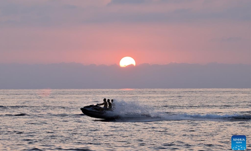 People sail a boat at sunset in the Mediterranean Sea in Beirut, Lebanon, on Aug. 23, 2023.(Photo: Xinhua)