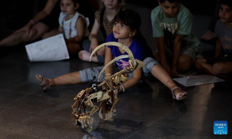 People visit the exhibition of handmade robots in the central Israeli city of Bat Yam on Aug. 22, 2023. These robots mimic the motions of animals like turtles and elephants, integrating elements of traditional puppetry into their mechanics and designs.(Photo: Xinhua)