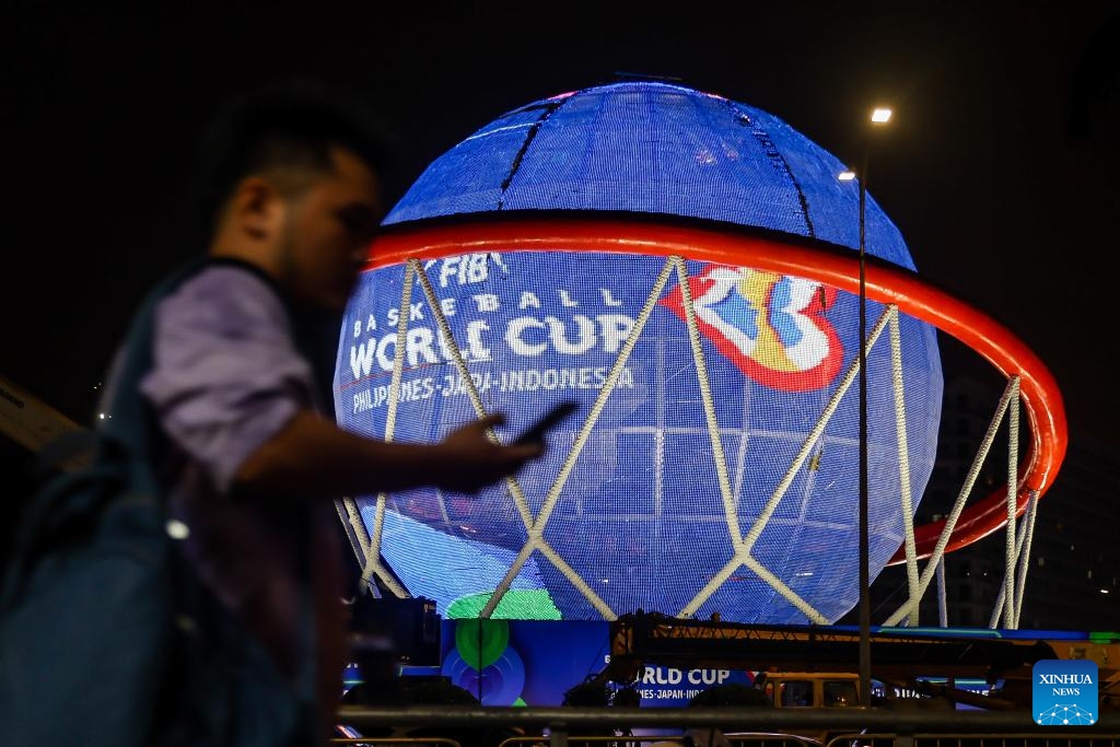 People walk past a giant FIBA Basketball World Cup themed display in Pasay City, the Philippines, Aug. 24, 2023. The FIBA Basketball World Cup 2023 will be held from Aug. 25 to Sept. 10, 2023.(Photo: Xinhua)