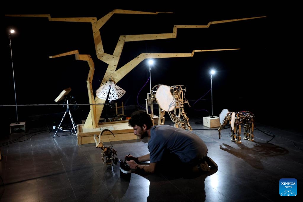 A man tests a robot at the exhibition of handmade robots in the central Israeli city of Bat Yam on Aug. 22, 2023. These robots mimic the motions of animals like turtles and elephants, integrating elements of traditional puppetry into their mechanics and designs.(Photo: Xinhua)