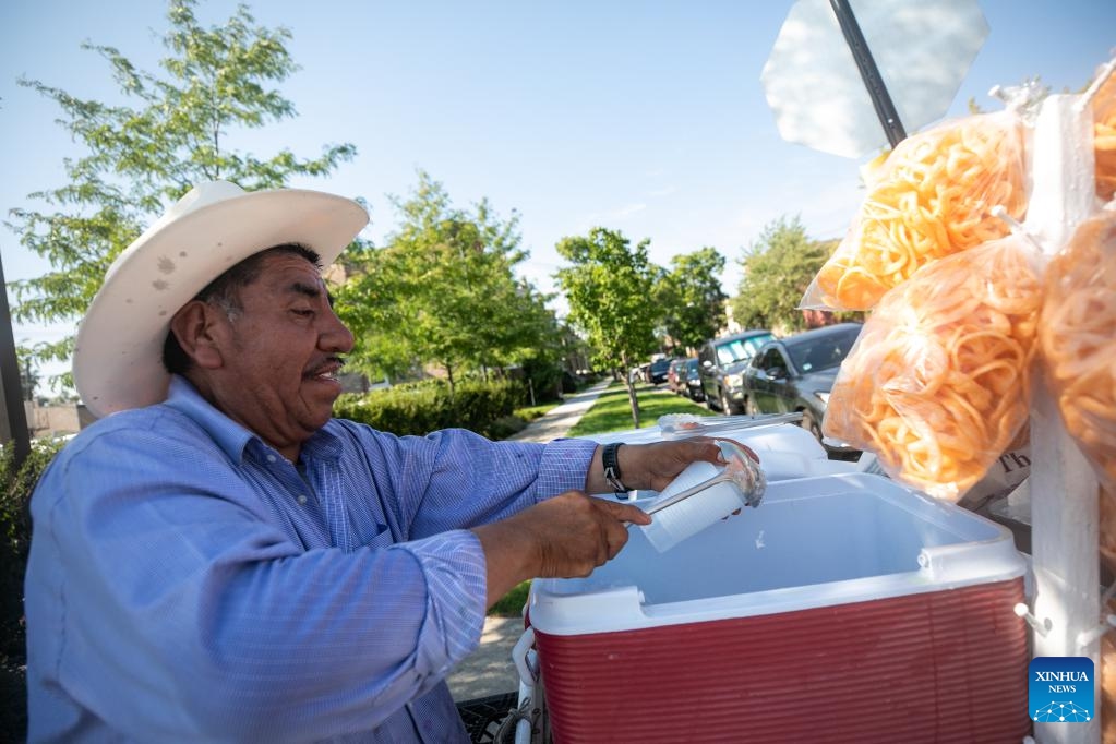 A man sells flavored ice snacks in the street in Chicago, the United States, on Aug. 23, 2023. The temperature at O'Hare International Airport in Chicago, the third most populous city in the United States, reached 98 degrees Fahrenheit (36.67 degrees Celsius) Wednesday afternoon, breaking the city's previous daily high temperature record for Aug. 23 of 97 degrees Fahrenheit (36.11 degrees Celsius), according to the U.S. National Weather Service.(Photo: Xinhua)