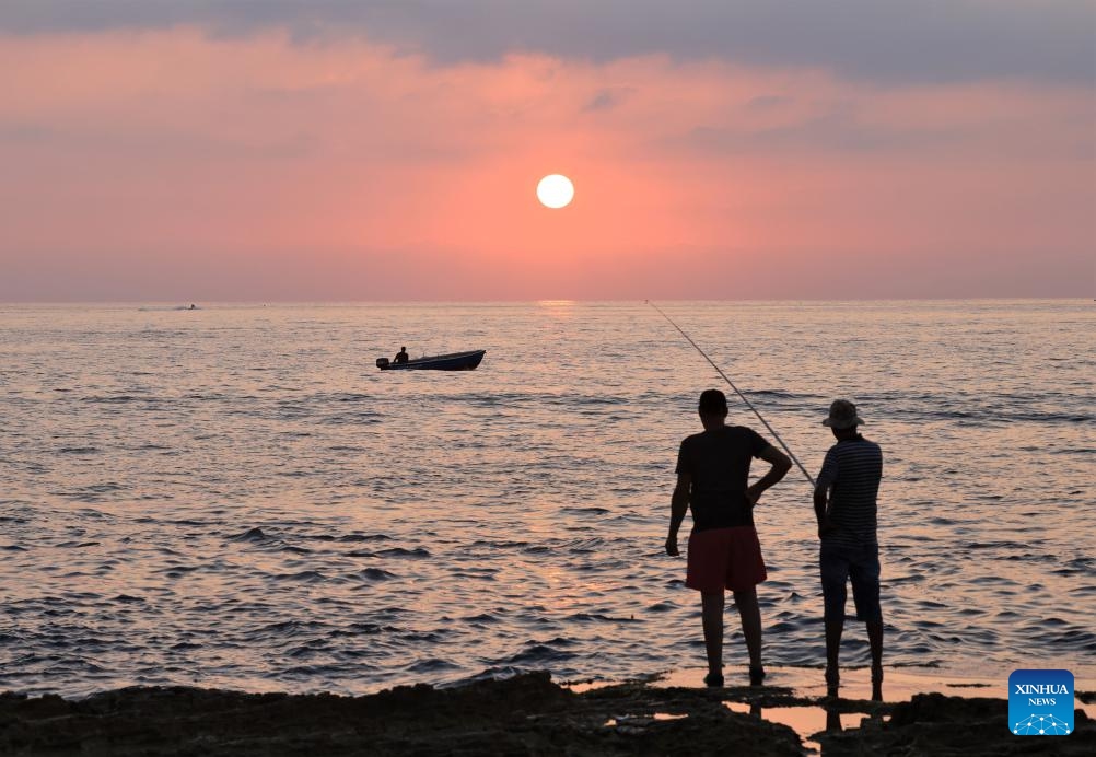 People fish at sunset by the Mediterranean Sea in Beirut, Lebanon, on Aug. 23, 2023.(Photo: Xinhua)