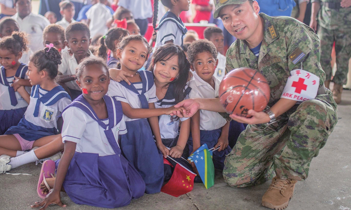 A Chinese naval officer from <em>Ark Peace</em> poses for a photo with some students in Chung Wah School of Honiara on August 22,  2023 Photo: Shan Jie/GT