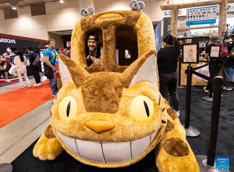 A man poses for photos on the Catbus during the 2023 Fan Expo Canada in Toronto, Canada, on Aug. 25, 2023. As one of the largest comics, sci-fi, anime and gaming events in Canada, the annual event is held here from Aug. 24 to Aug. 27, attracting hundreds of thousands of fans from across the world. Photo: Xinhua