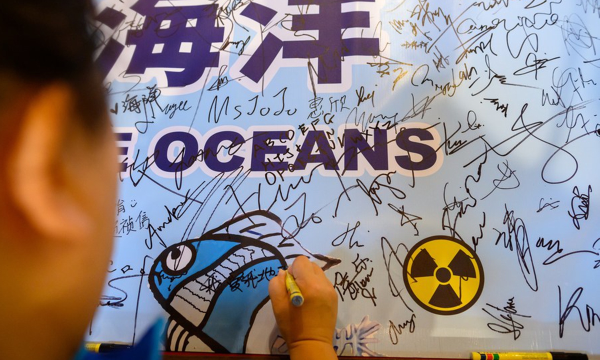 A protestor signs a poster during a rally against Japan's dumping of nuclear-contaminated wastewater into the ocean in Selangor state, Malaysia, on Aug. 27, 2023. (Photo by Chong Voon Chung/Xinhua) 


