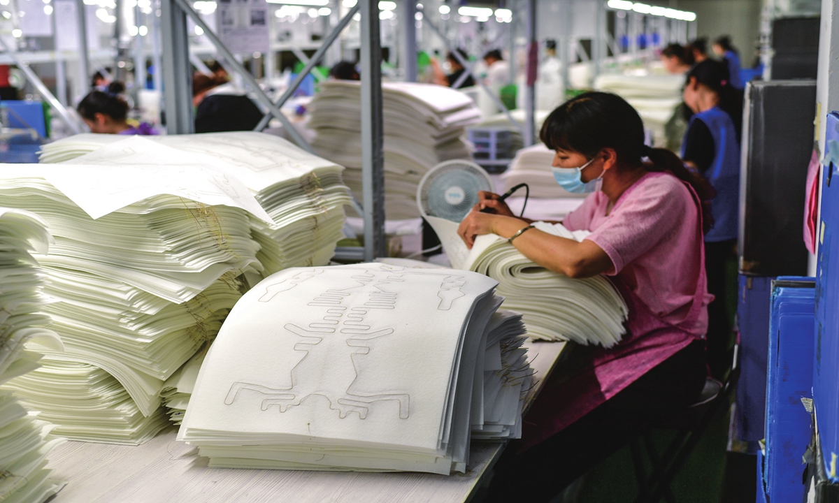 Workers catch up on orders for heating pads used for car seats at a private auto parts factory in Haian county, East China's Jiangsu Province on August 28, 2023. The government has been developing and strengthening local supply chains to ramp up manufacturing sector. Photo: cnsphoto