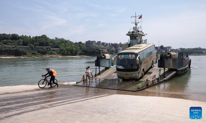 This photo taken on July 1, 2023 shows vehicles and passengers going ashore the Nixi south ferry in Xuzhou District of Yibin, southwest China's Sichuan Province. The cross-river vehicle ferry service that links Nixi Town and Juexi Town in Xuzhou District of Yibin started in May of 1992. This ferry service has been one of the most important transportation methods for local people living nearby on both sides of Minjiang River.(Photo: Xinhua)