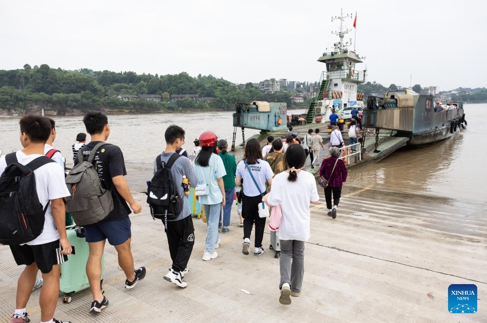 Passengers board the cross-river vehicle ferry linking Nixi Town and Juexi Town in Xuzhou District of Yibin, southwest China's Sichuan Province, Aug. 28, 2023. The cross-river vehicle ferry service that links Nixi Town and Juexi Town in Xuzhou District of Yibin started in May of 1992. This ferry service has been one of the most important transportation methods for local people living nearby on both sides of Minjiang River.(Photo: Xinhua)