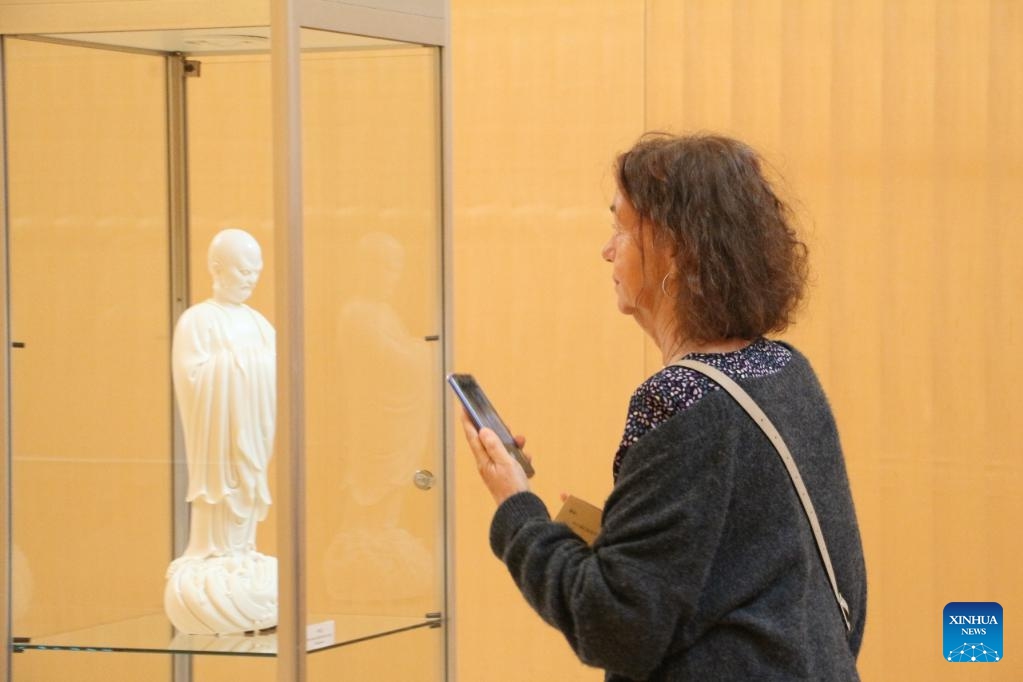 A visitor views an exhibit during an itinerant exhibition of Chinese Dehua white porcelain in Frankfurt, Germany, Aug. 29, 2023. An exhibition of the famous Chinese Dehua white porcelain is in full swing at the Stadthaus in Frankfurt, Germany. Over 90 items of Dehua white porcelain, known to European customers as Blanc de Chine, are on display at the exhibition.(Photo: Xinhua)