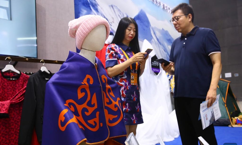 A trader learns about clothing products made of new materials at the environmental services exhibition of the 2023 China International Fair for Trade in Services (CIFTIS) in Beijing, capital of China, Sept. 2, 2023. Themed Opening-up leads development, cooperation delivers the future, the 2023 CIFTIS is being held in Beijing from Sept. 2 to 6 and features over 200 varied events, including forums, negotiations, and summits. (Photo: Xinhua)