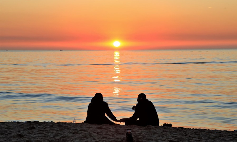 A couple watch sunset on the beach in Beirut, Lebanon, Jan. 8, 2022. Photo: Xinhua