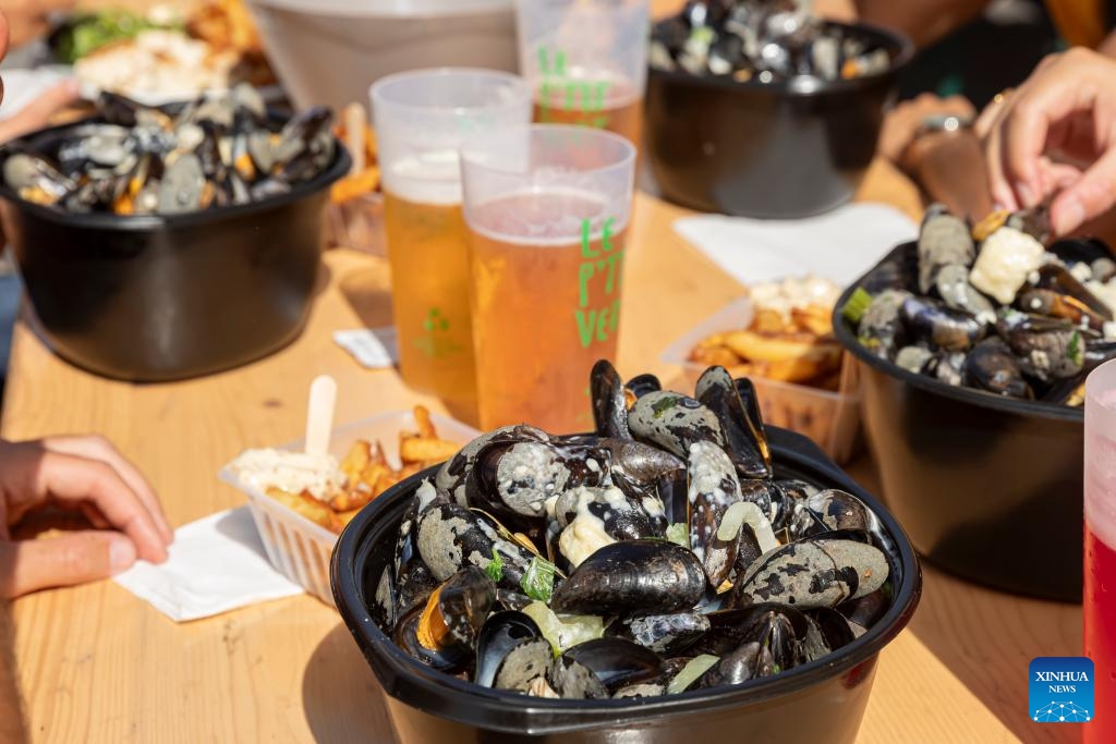 People enjoy mussels and beers during the annual Braderie de Lille (Lille flea market), in Lille, northern France, Sept. 3, 2023. The annual Braderie de Lille kicked off here on the first weekend of September. Mussels and french fries are popular food among tourists. (Photo: Xinhua)