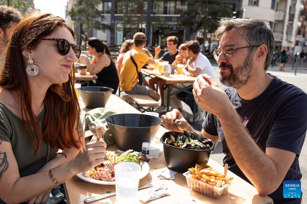 People enjoy mussels during the annual Braderie de Lille (Lille flea market), in Lille, northern France, Sept. 3, 2023. The annual Braderie de Lille kicked off here on the first weekend of September. Mussels and french fries are popular food among tourists.(Photo: Xinhua)