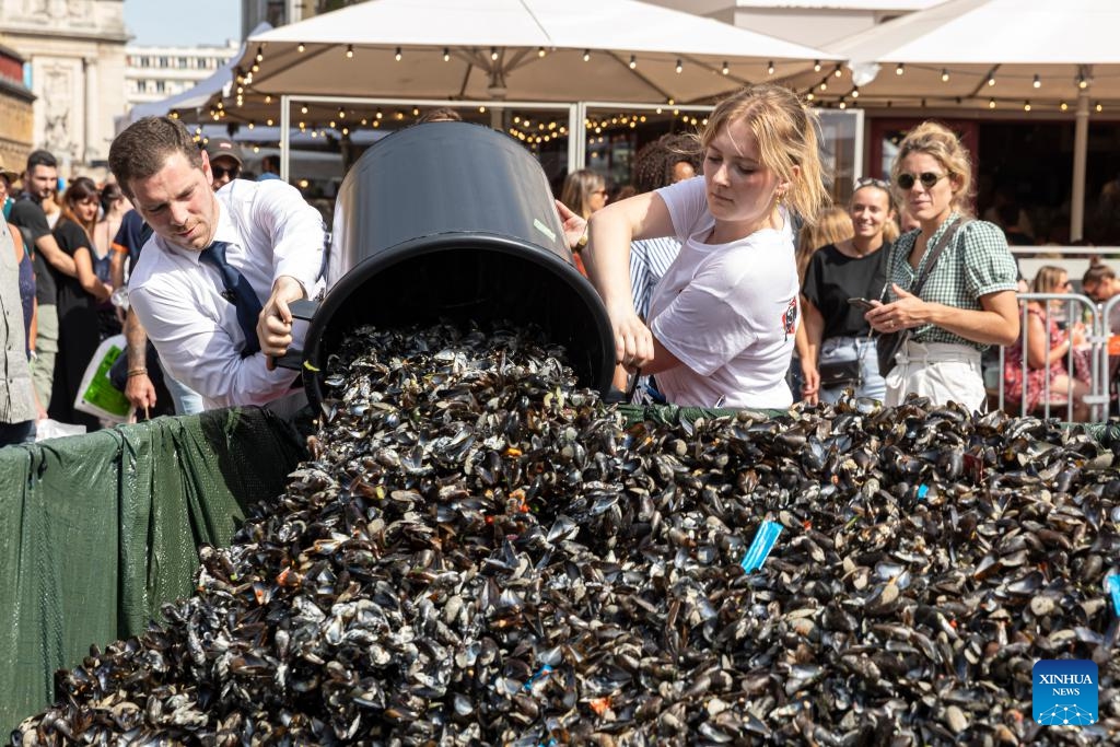 Waiters discard buckets of empty mussel shells into a collective bin during the annual Braderie de Lille (Lille flea market), in Lille, northern France, Sept. 3, 2023. The annual Braderie de Lille kicked off here on the first weekend of September. Mussels and french fries are popular food among tourists.(Photo: Xinhua)