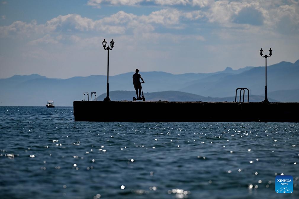 A man rides a scooter at Ohrid Lake in Struga, North Macedonia, on Sept. 3, 2023.(Photo: Xinhua)