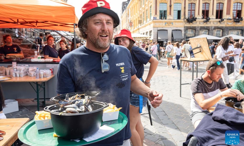 A waiter serves mussels during the annual Braderie de Lille (Lille flea market), in Lille, northern France, Sept. 3, 2023. The annual Braderie de Lille kicked off here on the first weekend of September. Mussels and french fries are popular food among tourists.(Photo: Xinhua)