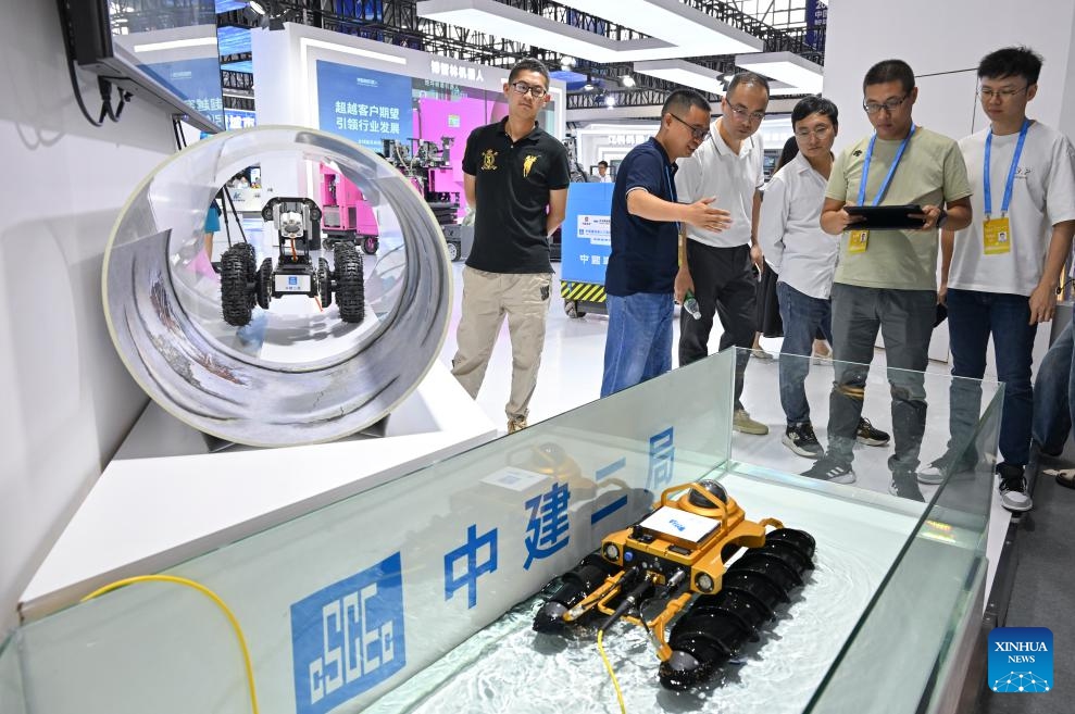 Visitors look at a robot at the booth of China Construction Second Engineering Bureau during the Smart China Expo 2023 in southwest China's Chongqing Municipality, Sept. 4, 2023. The Smart China Expo 2023 opened at Chongqing International Expo Center on Monday. Scheduled until Wednesday, this year's expo focuses on smart, connected new energy vehicles. It has attracted over 500 exhibitors from home and abroad to display their cutting-edge technologies, products, and applications in smart industries and the digital economy.(Photo: Xinhua)