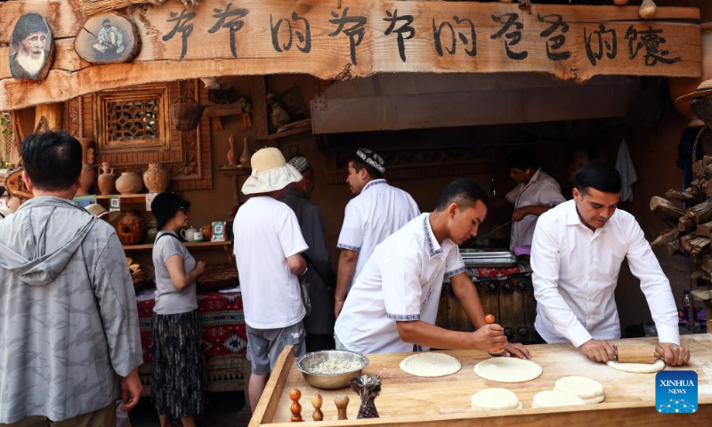 Staff members make nang, a local flatbread, at the ancient city of Kashgar scenic area in Kashgar, northwest China's Xinjiang Uygur Autonomous Region, Sept. 7, 2023. The ancient city of Kashgar, located in southwestern Xinjiang, is the largest complex of raw earth buildings still in use in the world. (Xinhua/Lan Hongguang)