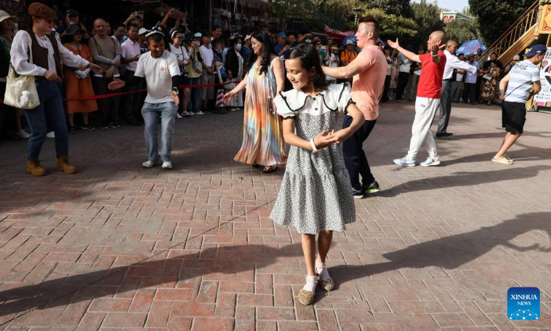 People dance at the ancient city of Kashgar scenic area in Kashgar, northwest China's Xinjiang Uygur Autonomous Region, Sept. 7, 2023. The ancient city of Kashgar, located in southwestern Xinjiang, is the largest complex of raw earth buildings still in use in the world. (Xinhua/Lan Hongguang)