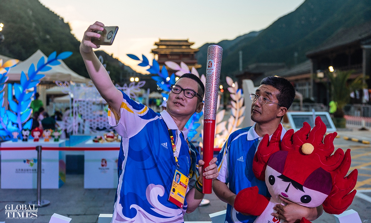 Visitors take a photo with the torch and mascot of Beijing 2008 Olympic Games on August 16, 2023. Photo: Li Hao/Global Times