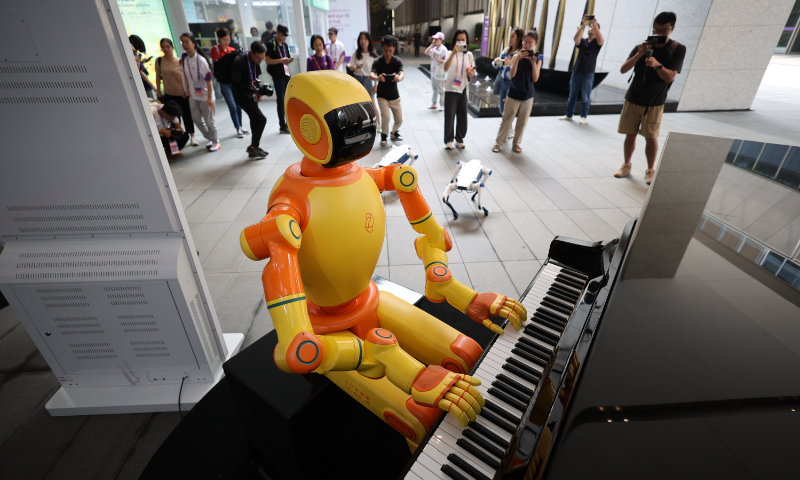 A robot plays piano to welcome guests at the Hangzhou Asian Games Village in East China's Zhejiang Province on September 12, 2023. A series of intelligent scenarios have been launched in the village, including an augmented reality smart bus and a fitness experience empowered by the metaverse. Photo: VCG