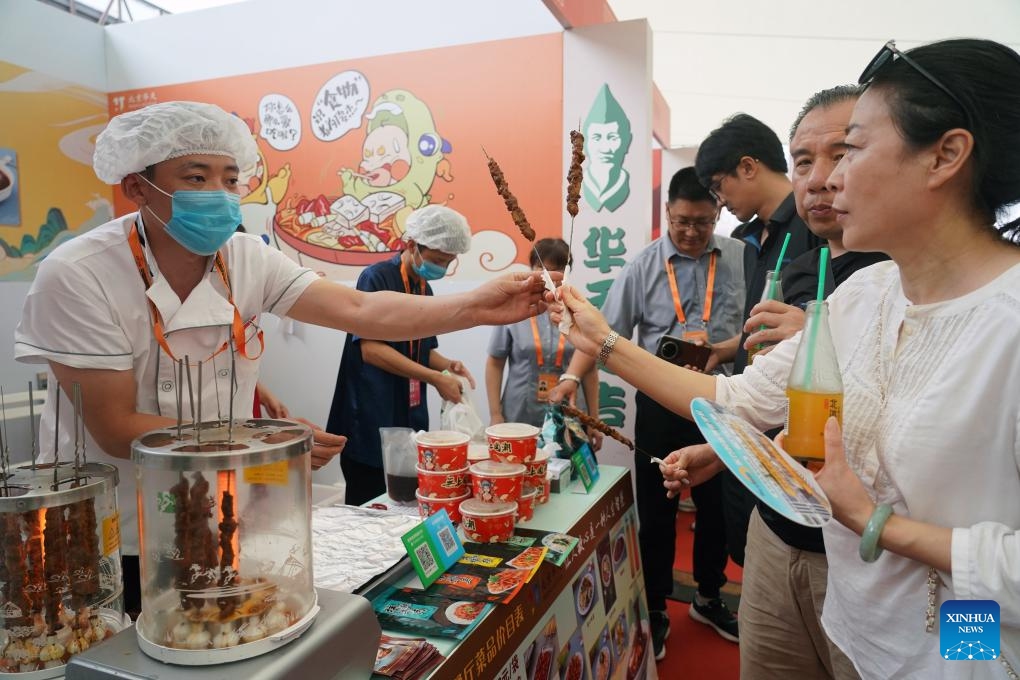 Visitors try snacks at the exhibition hall of Beijing time-honored brand during the 2023 China International Fair for Trade in Services (CIFTIS) in Beijing, capital of China, Sept. 6, 2023. A number of time-honored brands in catering business made their debut at the exhibition hall of Beijing time-honored brand during the 2023 CIFTIS, attracting numerous guests to come for a taste.(Photo: Xinhua)