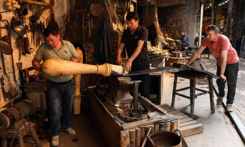 Handicraftsmen make ironware at the ancient city of Kashgar scenic area in Kashgar, northwest China's Xinjiang Uygur Autonomous Region, Sept. 7, 2023. The ancient city of Kashgar, located in southwestern Xinjiang, is the largest complex of raw earth buildings still in use in the world. (Xinhua/Lan Hongguang)