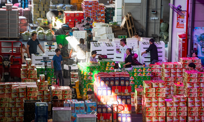 Workers load and unload domestic and imported fruits at a wholesale fruit market in Jinhua, East China's Zhejiang Province, on September 11, 2023. In order to meet the sales peak of the Mid-Autumn Festival and the National Day holidays that fall from September 29 to October 6, wholesale operators are stocking up in advance. Photo: VCG