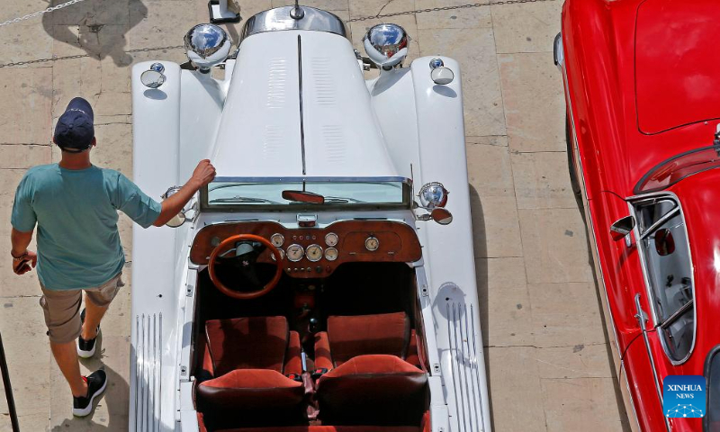 A man poses for photos with a classic car during a classic car show held in Deir el Qamar, Mount Lebanon Governorate, Lebanon, on Sept. 10, 2023. A classic car show was held Sunday in Deir el Qamar, a historic town in south-central Lebanon, featuring about 50 classic cars from different eras. (Xinhua/Bilal Jawich)