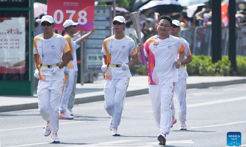 Torch bearer Yu Jianxin runs with the torch during the torch relay of the 19th Asian Games in Shaoxing, east China's Zhejiang Province, Sept. 11, 2023. (Xinhua/Xu Yu)