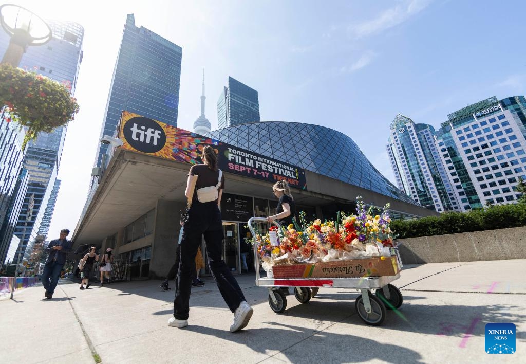 People walk under a Toronto International Film Festival (TIFF) poster in Toronto, Canada, on Sept. 7, 2023. The TIFF kicked off here on Thursday.(Photo: Xinhua)