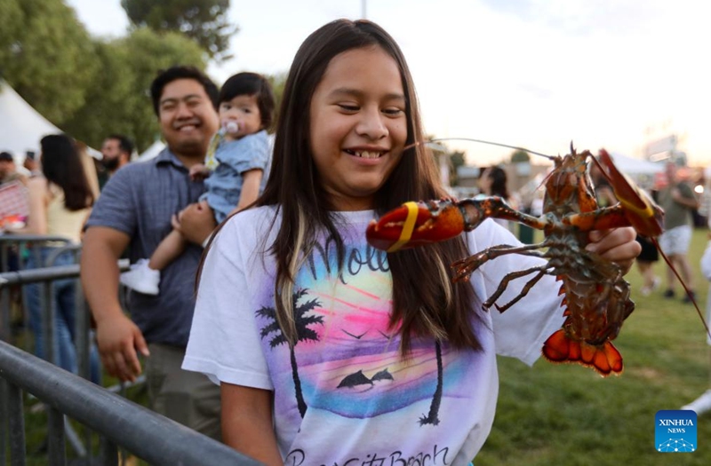 A girl displays a lobster during the Original Lobster Festival in Fountain Valley, California, the United States, on Sept. 8, 2023. Photo: Xinhua