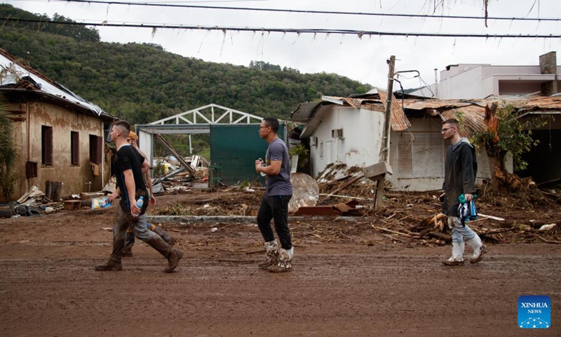 People walk by buildings destroyed by flood at the city of Mucum, Rio Grande do Sul, Brazil, on Sept. 9, 2023. Photo: Xinhua