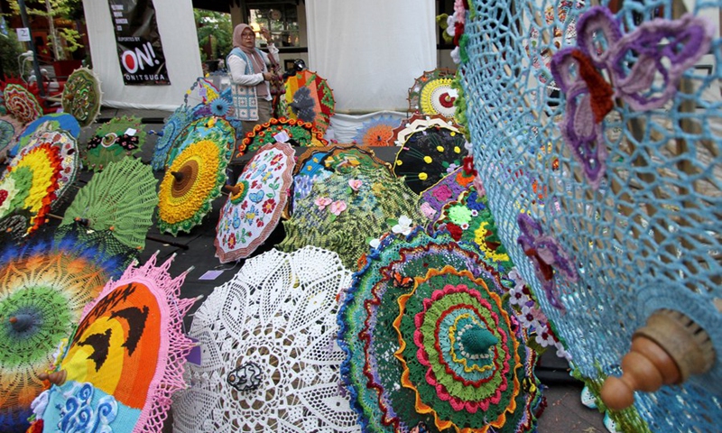 A woman walks past a variety of umbrellas on display during Indonesia Umbrella Festival 2023 in Surakarta, Central Java, Indonesia on Sept. 9, 2023. Photo: Xinhua