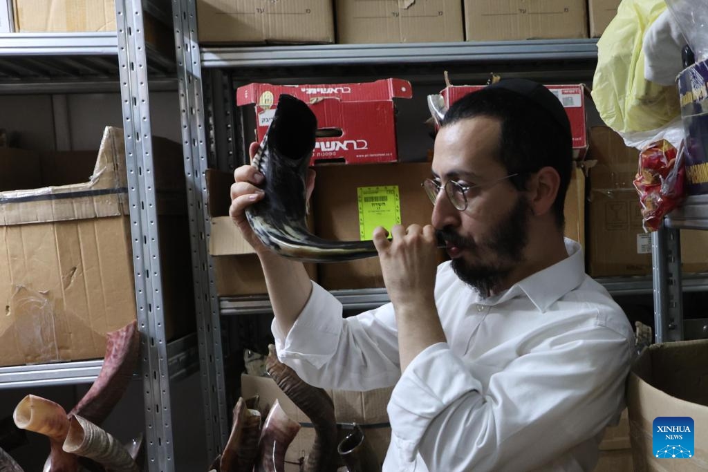 A man tries to blow a shofar at a factory in Tel Aviv, Israel, on Sept. 10, 2023. Jews blow the traditional shofar or ram's horn while praying in synagogues during the holiday of Rosh Hashanah, the Jewish New Year.(Photo: Xinhua)