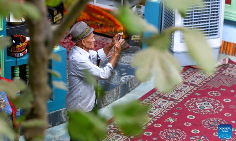 A tourist takes photos at the ancient city of Kashgar scenic area in Kashgar, northwest China's Xinjiang Uygur Autonomous Region, Sept. 7, 2023. The ancient city of Kashgar, located in southwestern Xinjiang, is the largest complex of raw earth buildings still in use in the world.(Photo: Xinhua)