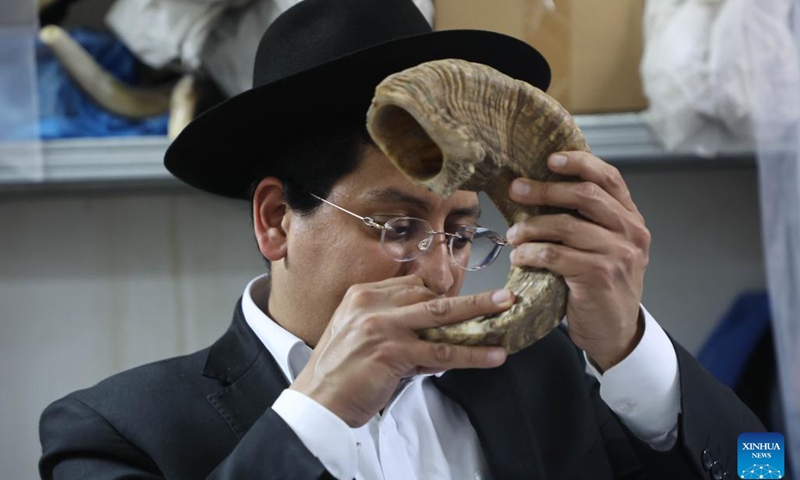 A man tries to blow a shofar at a factory in Tel Aviv, Israel, on Sept. 10, 2023. Jews blow the traditional shofar or ram's horn while praying in synagogues during the holiday of Rosh Hashanah, the Jewish New Year.(Photo: Xinhua)