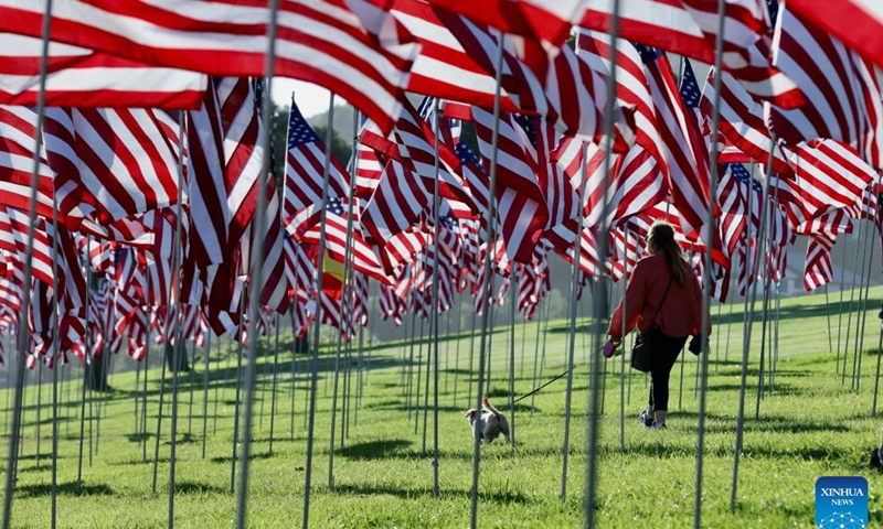 A woman walks among the Waves of Flags at Pepperdine University in Malibu, California, the United States, on Sept. 10, 2023. Each September, the university stages the Waves of Flags display to honor the victims of the 9/11 attacks.(Photo: Xinhua)