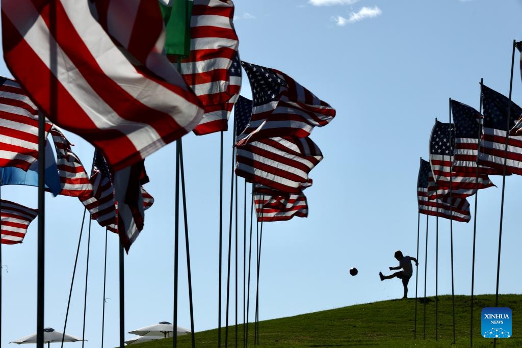 A boy plays a ball near the Waves of Flags at Pepperdine University in Malibu, California, the United States, on Sept. 10, 2023. Each September, the university stages the Waves of Flags display to honor the victims of the 9/11 attacks.(Photo: Xinhua)