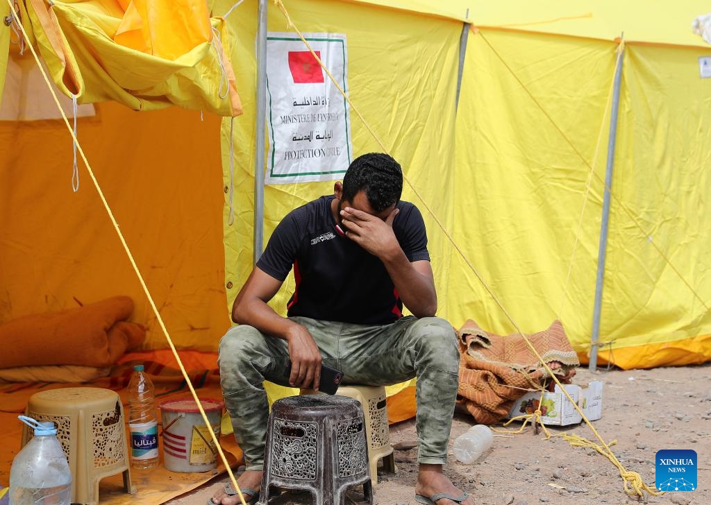 A man sits in front of a temporary shelter in Al Haouz Province, Morocco, Sept. 12, 2023. The death toll from the devastating earthquake in Morocco has risen to 2,901, and the injuries to 5,530, according to the latest statement released by the Moroccan government on Tuesday.(Photo: Xinhua)