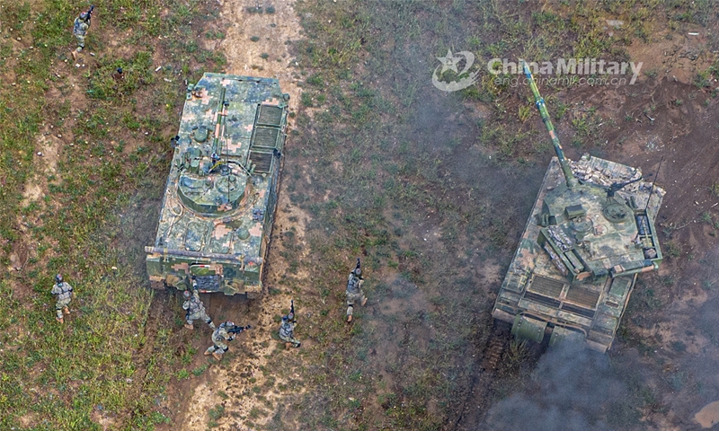 Two armored vehicles attached to a brigade under the PLA 73rd Group Army stay in combat formation and engage in coordinated operation. The training was organized in special terrain conditions and simulated real-combat environment, aiming to test the troops’ comprehensive combat capability in unfamiliar environments and emergency situations. (eng.chinamil.com.cn/Photo by Liu Zhiyong)